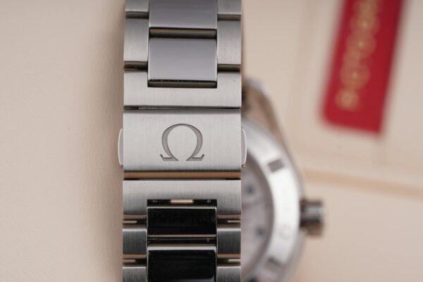 Detailed close-up of a luxury silver watch bracelet with Omega branding.