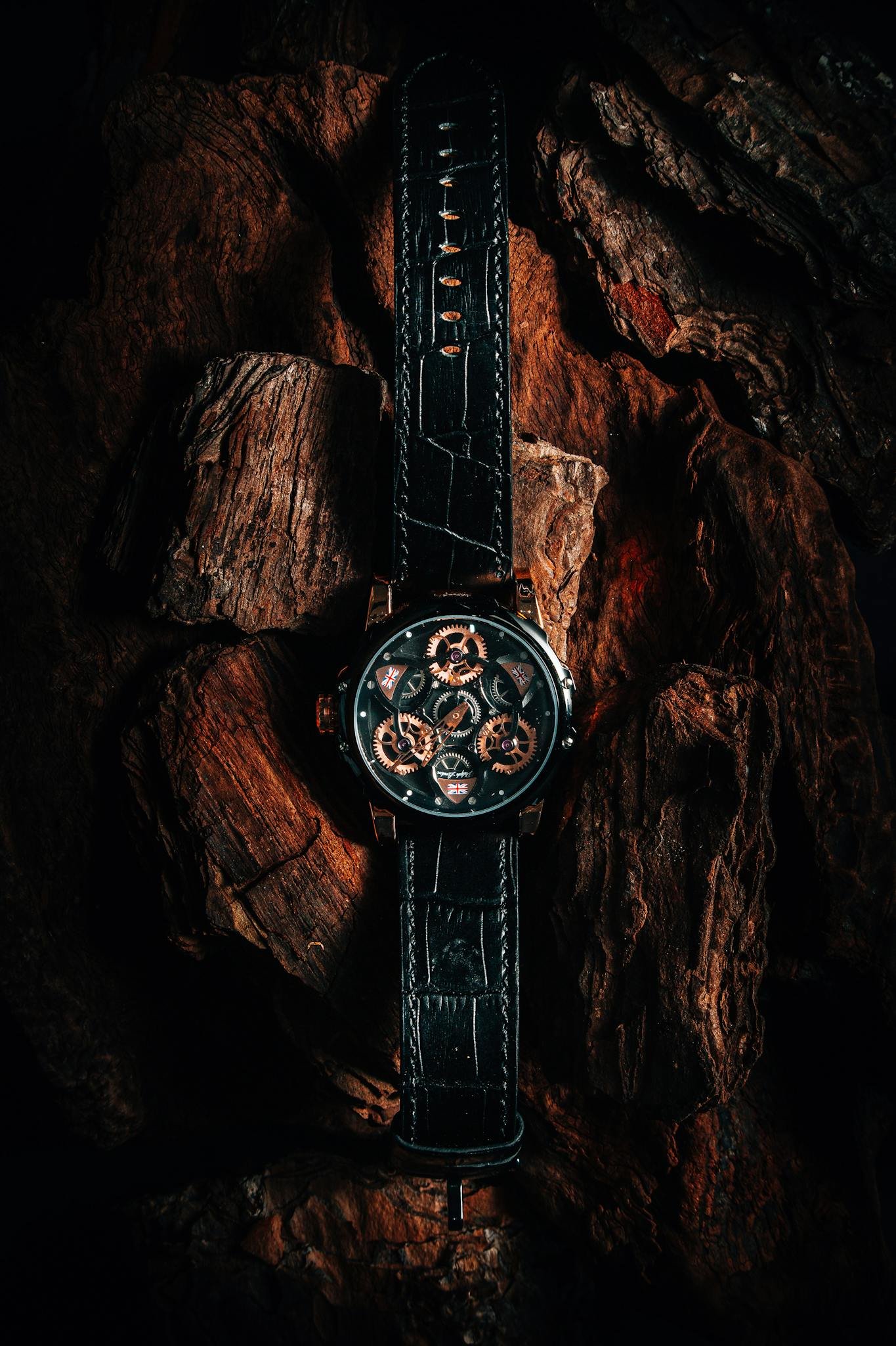 Elegant black leather watch with gears on dark wood. Perfect for luxury themes.